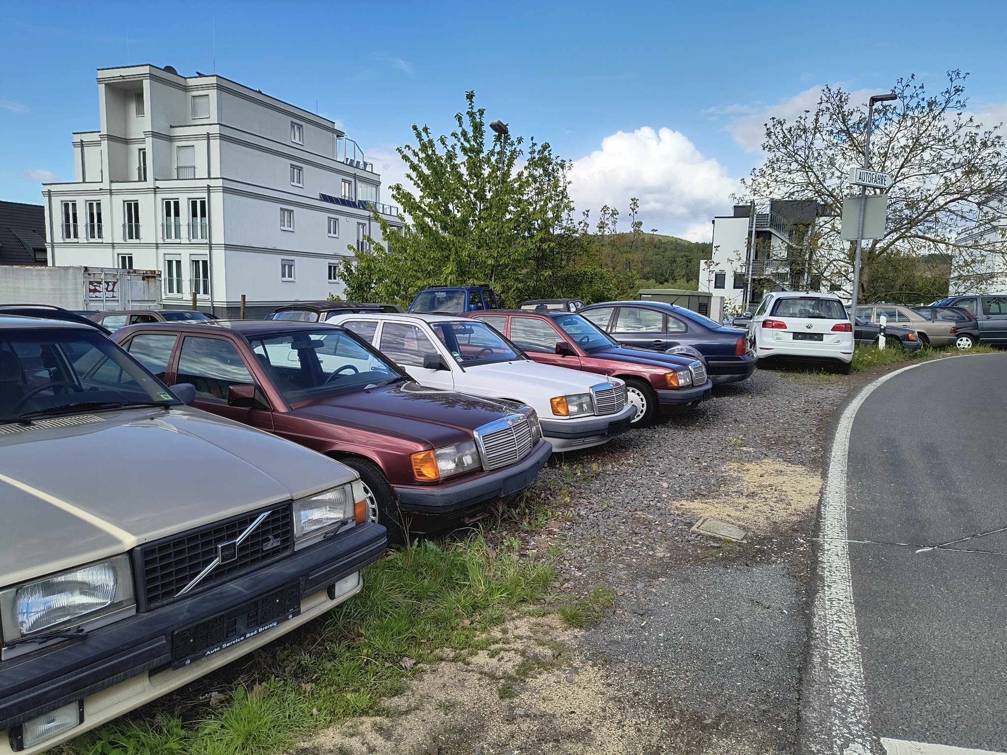 Fahrzeughof mit Volvo 240 und mehreren Mercedes-Limousinen an der Straße